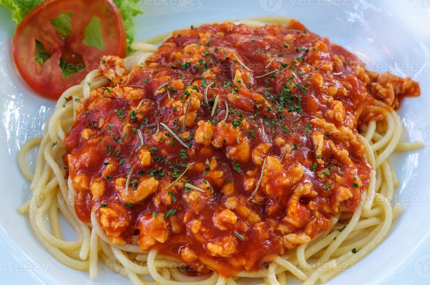 Closeup of the spaghetti red sauce with the minced pork in the withe plate. photo