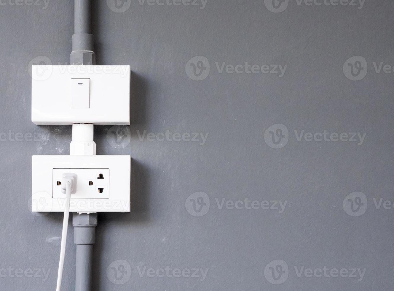 White electrical outlet and light bulb switch. photo