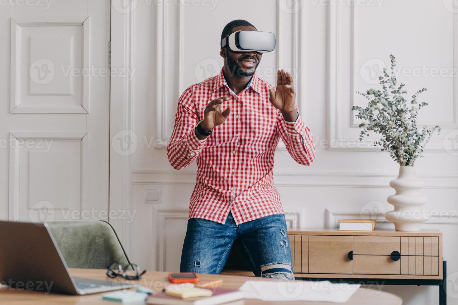 African man in VR headset interacting with digital interface, using innovative device for business photo