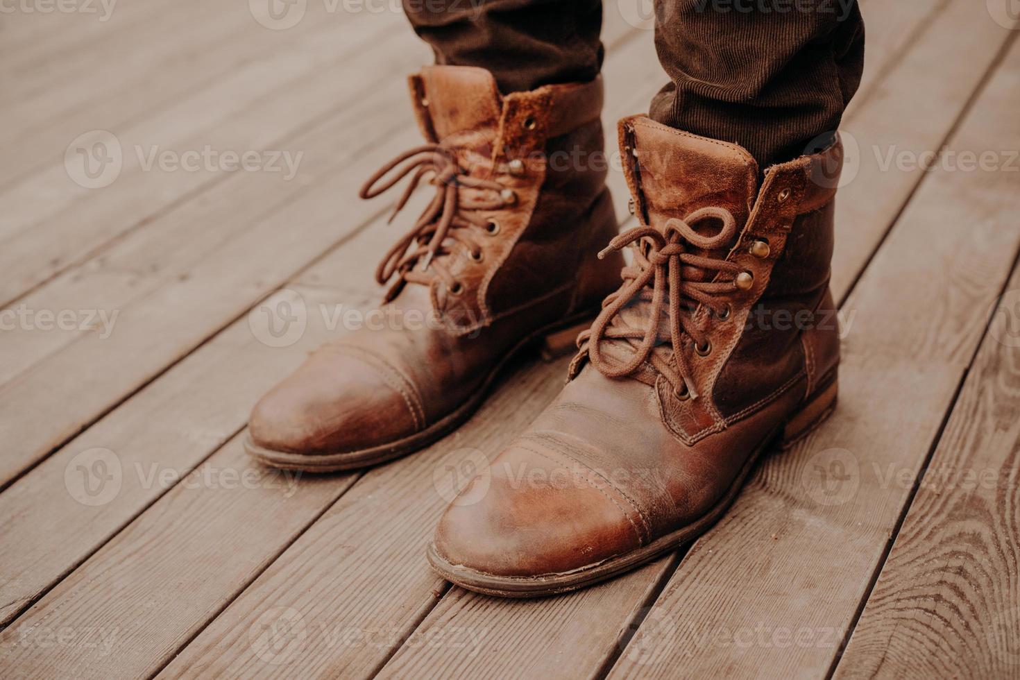vista superior de los zapatos del hombre en el piso o superficie de madera. calzado viejo. hombre irreconocible. botas marrones de cordones 8836412 de stock Vecteezy