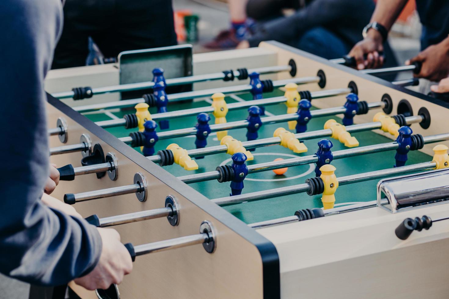 Men colleagues enjoy table soccer game after working day, have free time, like to play board games. Rest of young people during spare time photo