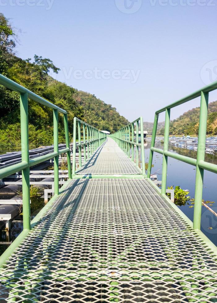 Long metal bridge is floating on the reservoir. photo