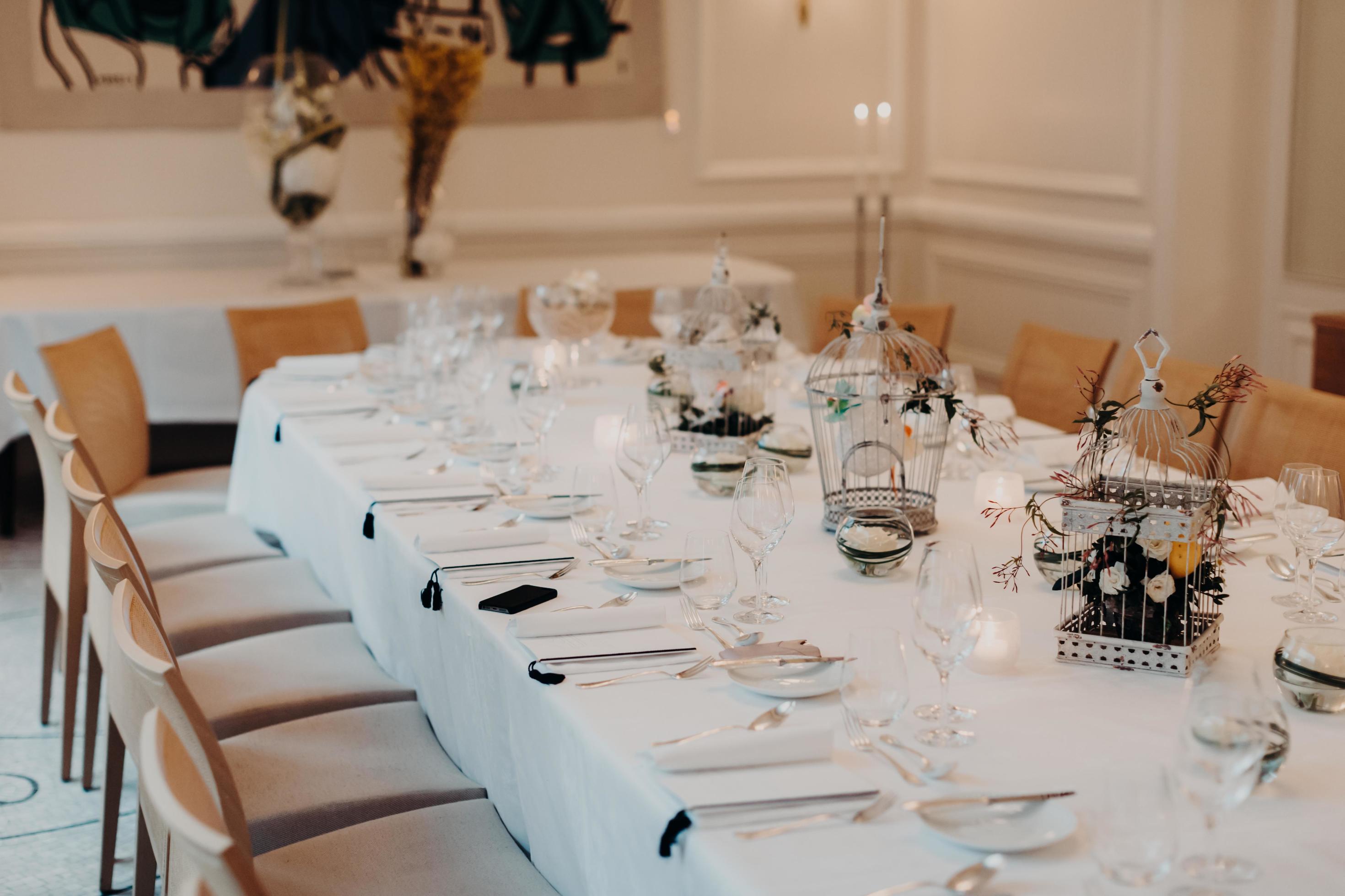 Elegante banquete en una mesa ornamentada con vajilla de cristal y  cubiertos generados por ia