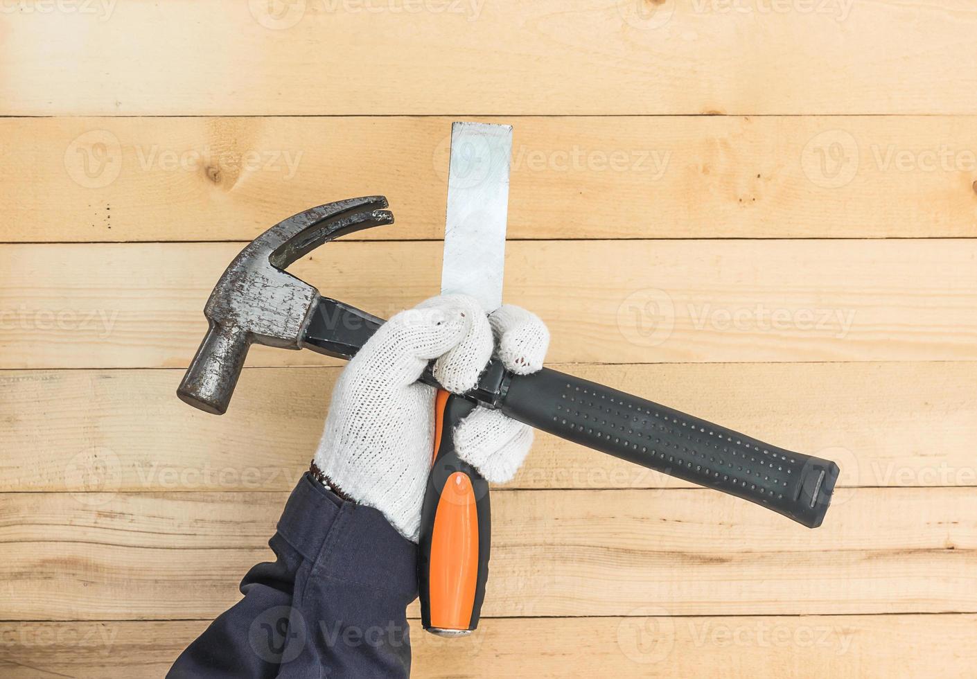 Hand in glove holding chisel and hammer photo