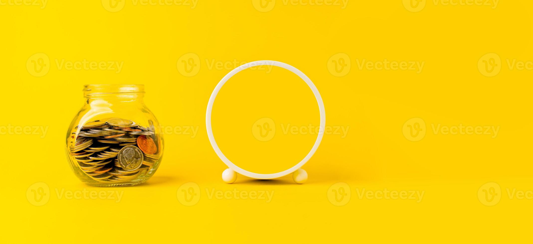 Money coin in glass jar, money saving concept with copy space on yellow background. photo