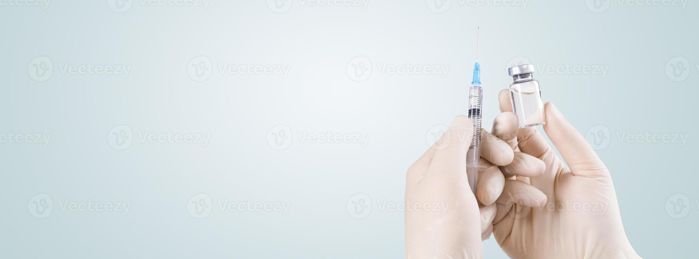 Hand holding syringe with vaccine against corona virus. photo