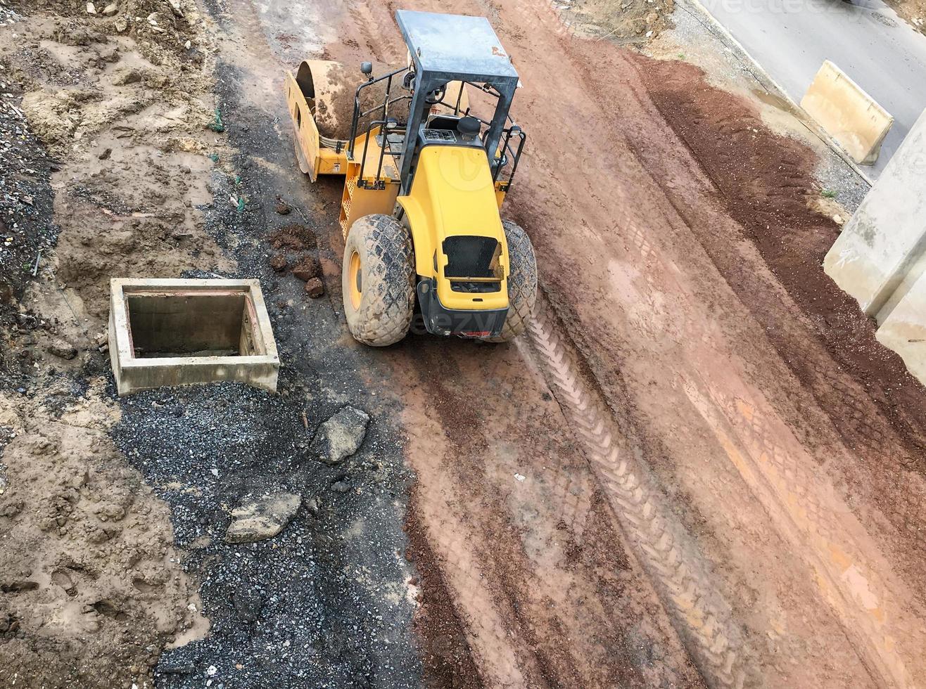 Compact yellow steamroller is parked. photo