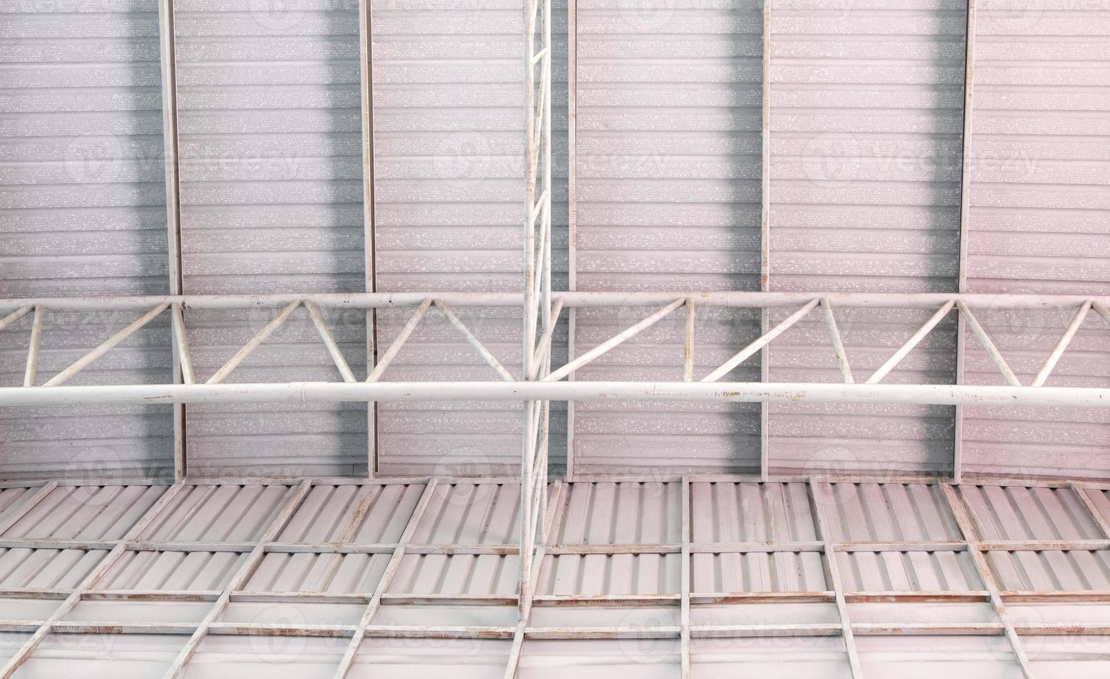 The metal frame of the roof structure with the roof tile covers the large warehouse. photo