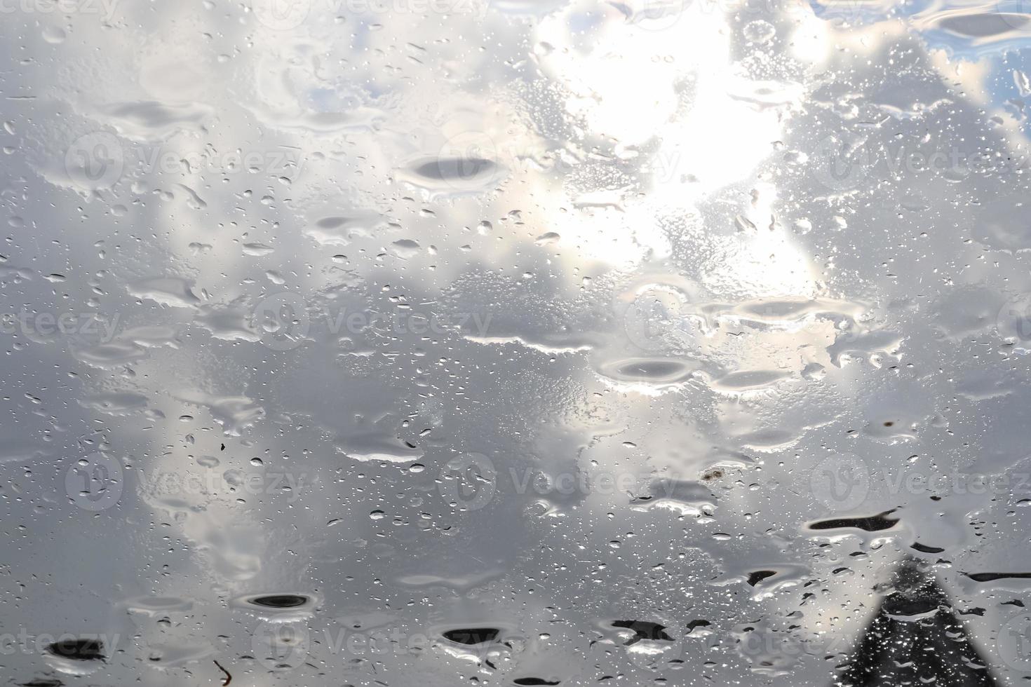 Rain drops running down a car window in a close up view. photo