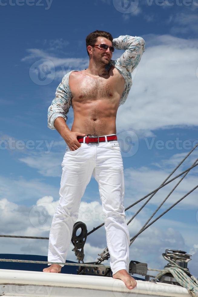 Young man sailing his boat on the open ocean photo