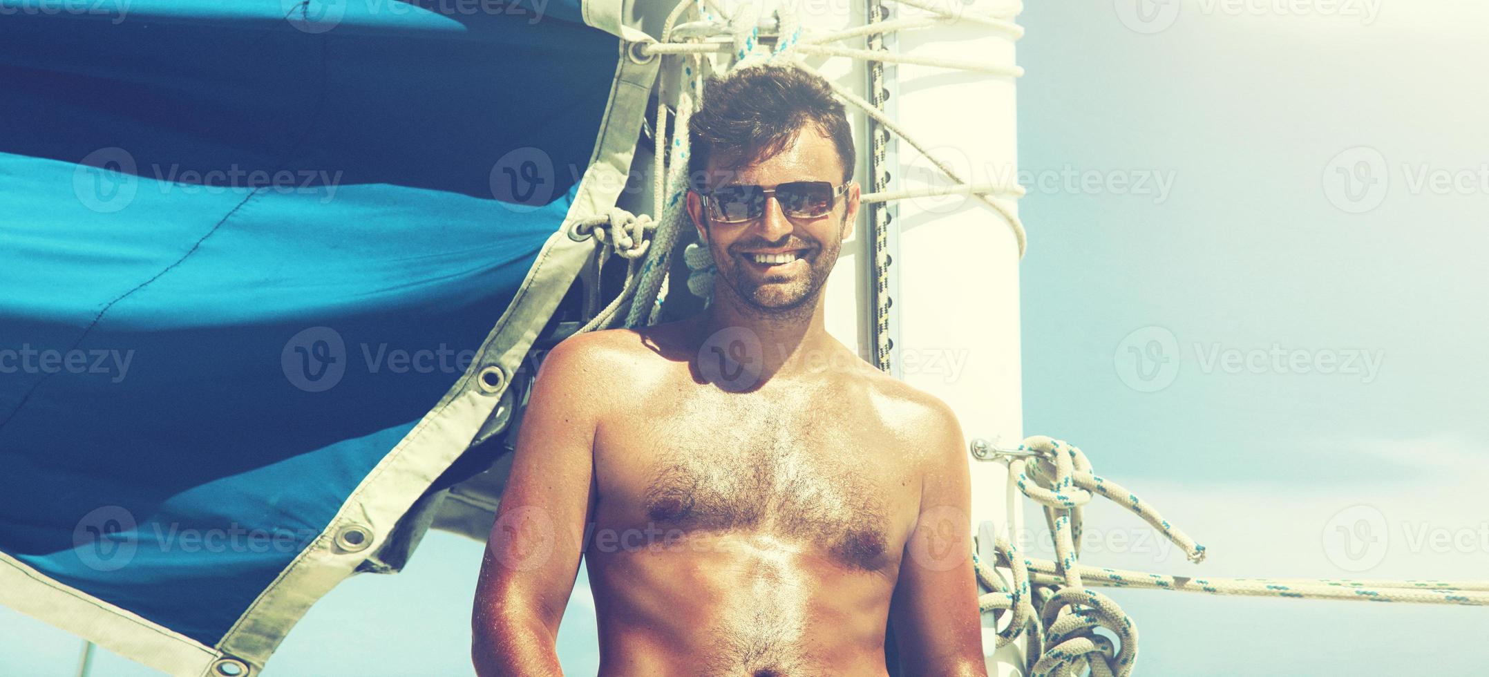 Young man sailing his boat on the open ocean photo