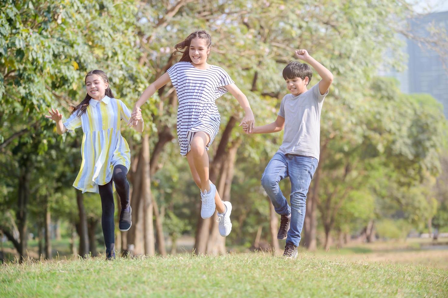 A half-Thai-Indian boy and a half-Thai-European girl friend races in a park while learning outside of school photo