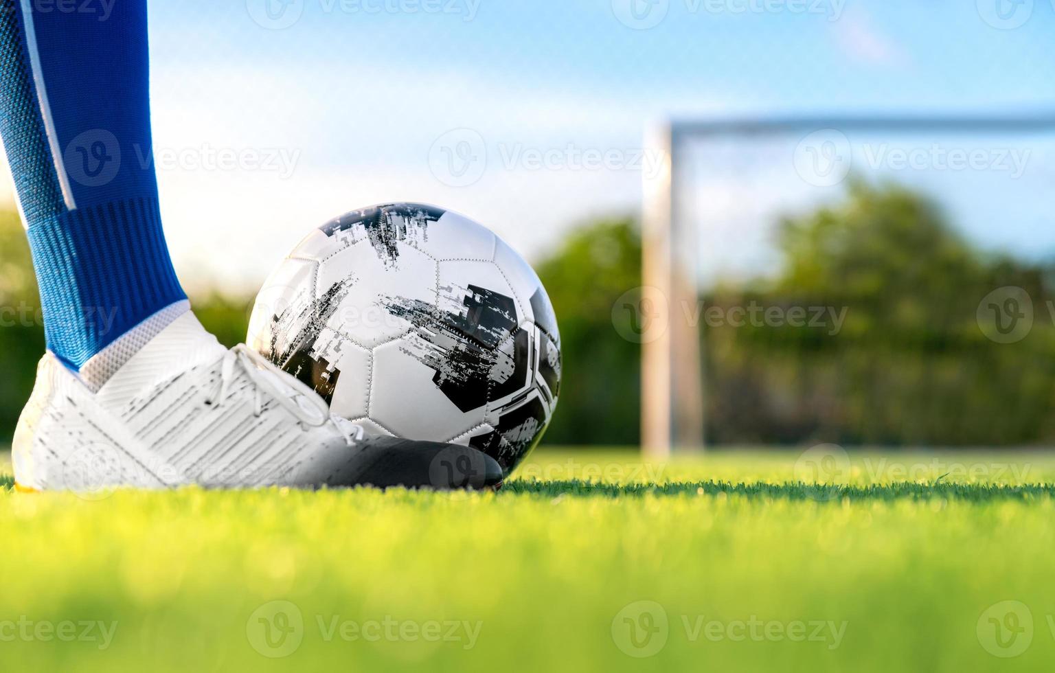 jugador profesional de fútbol o fútbol patea y dispara el balón en penal o freekick al portero por ganar el gol del campeón en la liga final en el estadio de campo foto