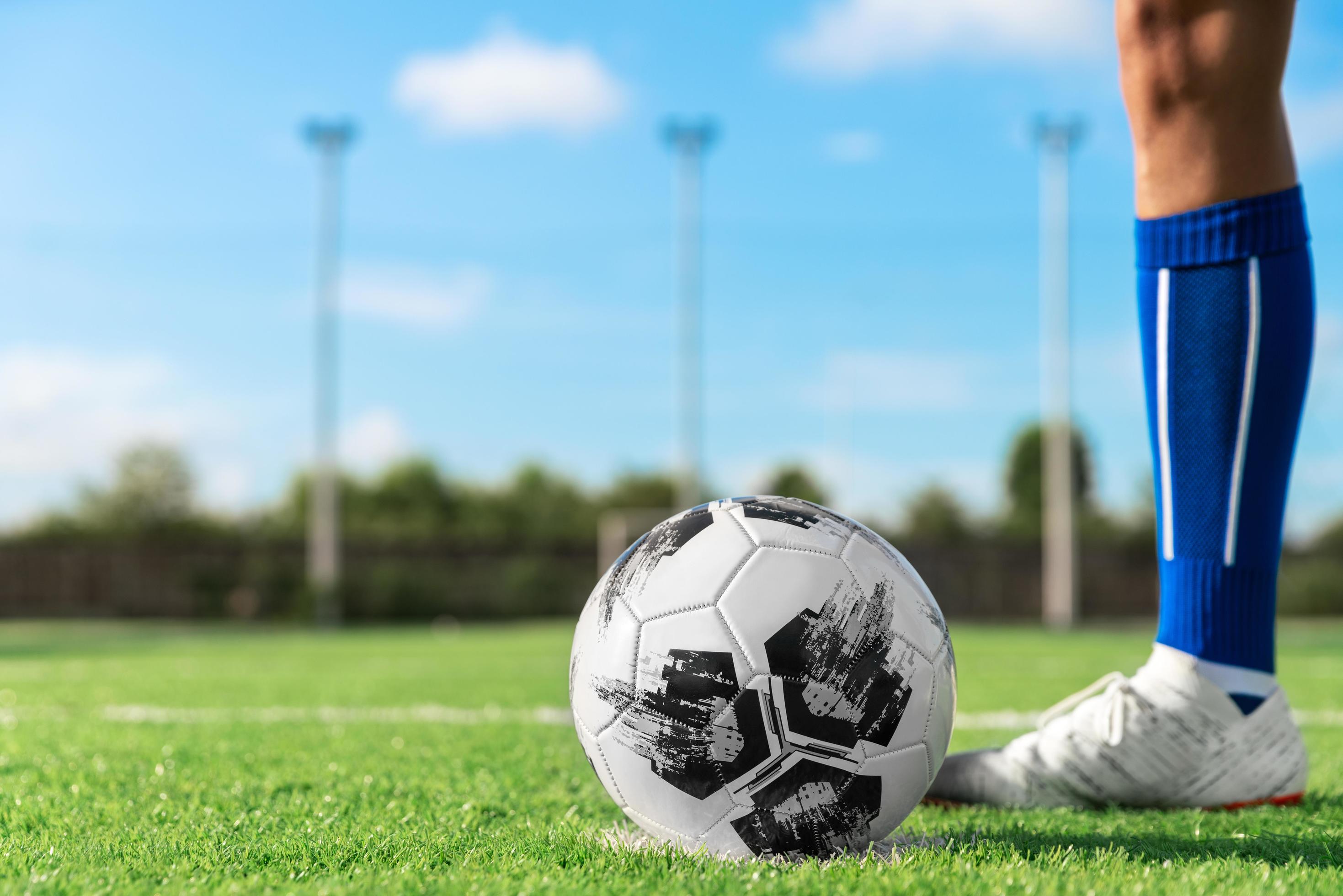 professional football or soccer player kick and shoot ball at penalty or freekick to goalkeeper