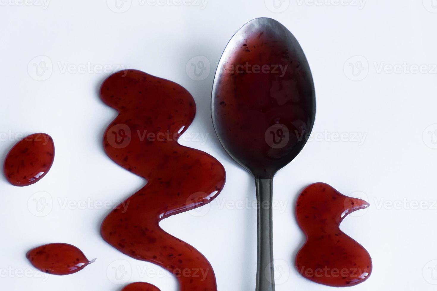 the drops of homemade sauce and a spoon on a white background photo