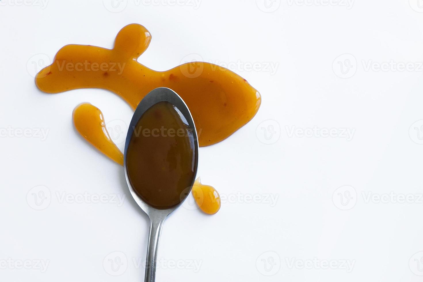 the drops of homemade sauce and a spoon on a white background photo