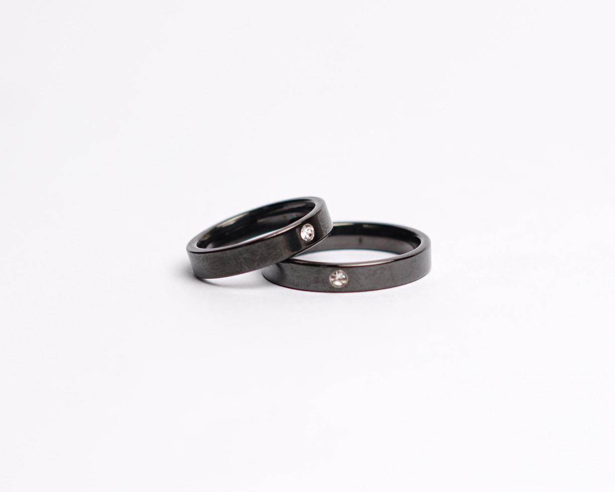 Jewelery ring with diamonds. Wedding rings that have deep meaning and significance. Engagement ring with gemstones. Wedding ring isolated on white background, focus blur. Pair in gold, silver, black. photo