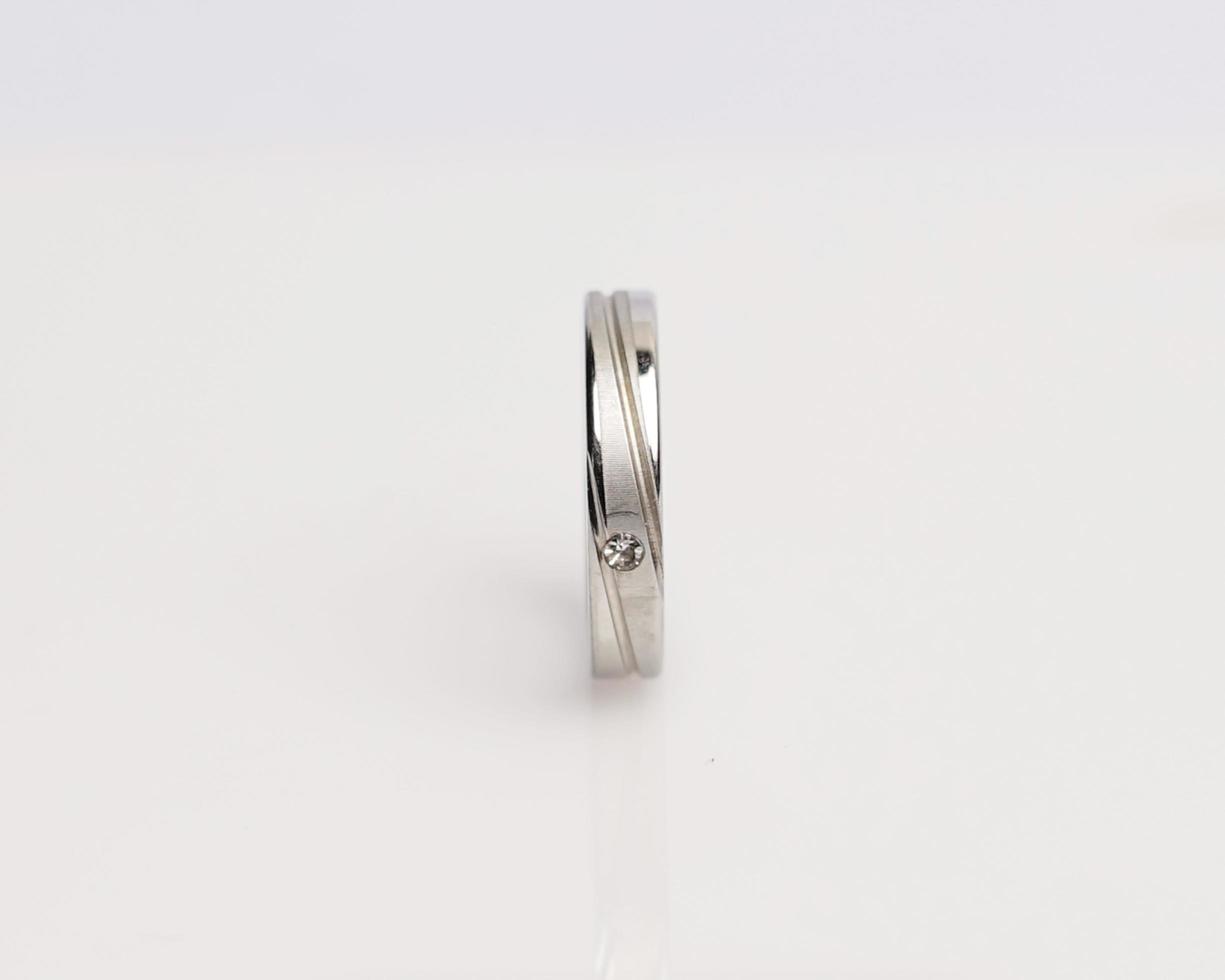 Jewelery ring with diamonds. Wedding rings that have deep meaning and significance. Engagement ring with gemstones. Wedding ring isolated on white background, focus blur. Pair in gold, silver, black. photo