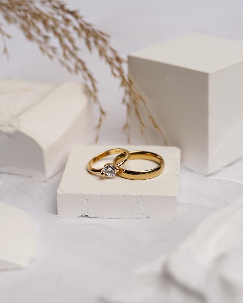 Wedding ring set on white stone. The jewelry ring is ready to be showcased and sold. The wedding ring is a sign of the love of the couple. Pearls and diamonds complete the ring's beauty. focus blur. photo