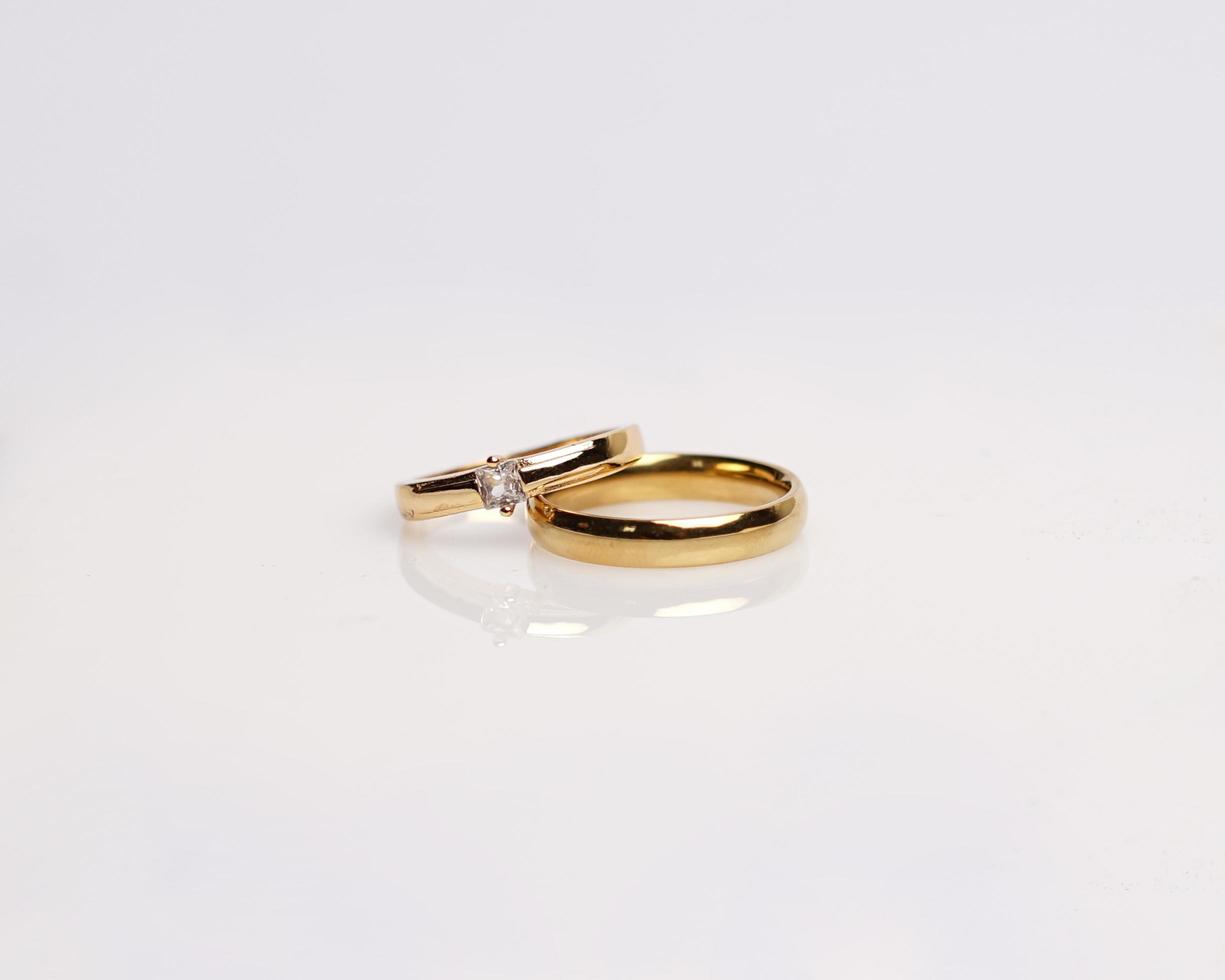 Jewelery ring with diamonds. Wedding rings that have deep meaning and significance. Engagement ring with gemstones. Wedding ring isolated on white background, focus blur. Pair in gold, silver, black. photo