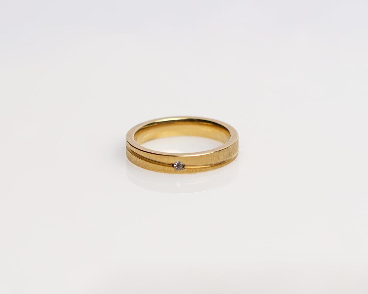 anillo de joyería con diamantes. anillos de boda que tienen un profundo significado y significado. anillo de compromiso con piedras preciosas. anillo de boda aislado sobre fondo blanco, enfoque borroso. par en oro, plata, negro. foto