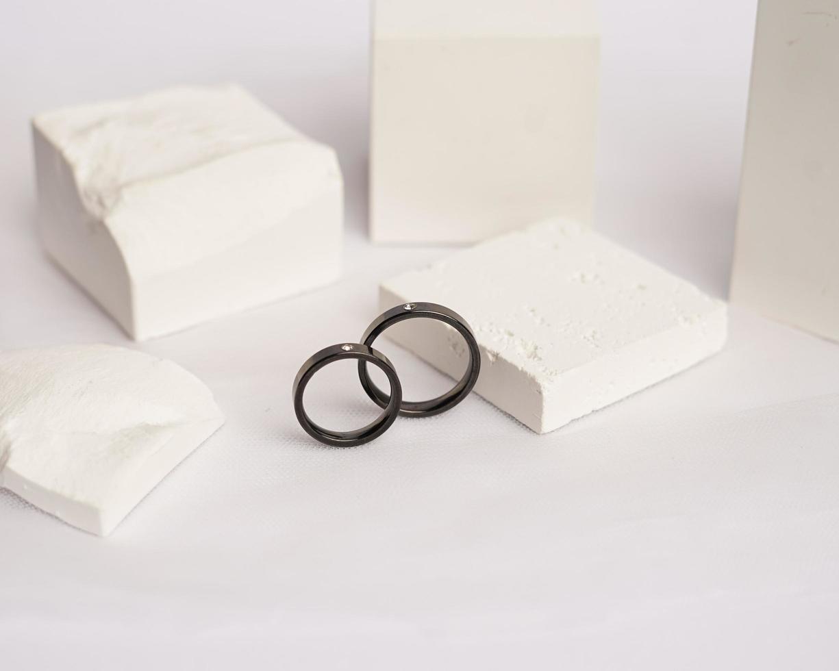 Diamond jewelery ring for social media display. Wedding ring photographed on white stone. Engagement ring with gemstones. Wedding rings isolated on a bright white background, focus blur. Gold ring. photo