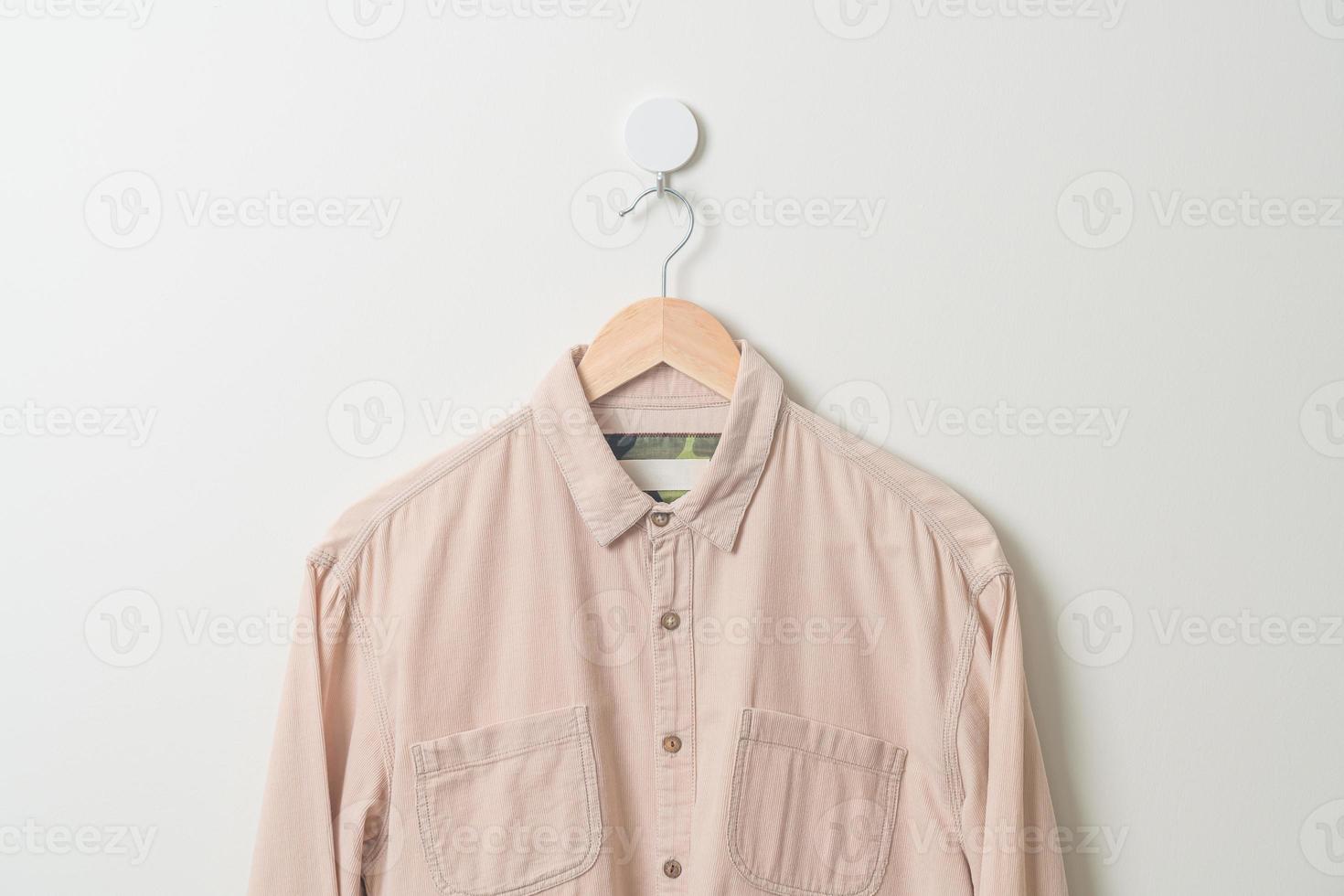 hanging shirt with wood hanger on wall photo