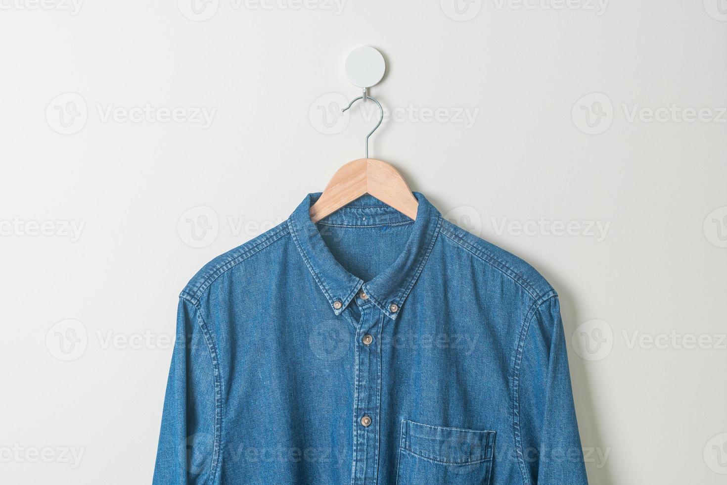 hanging shirt with wood hanger on wall photo