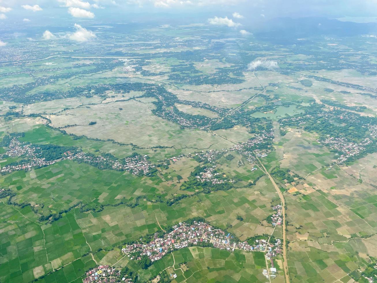 The aerial landscape shows a green view of the city. Streets, rice fields, and village houses. photo