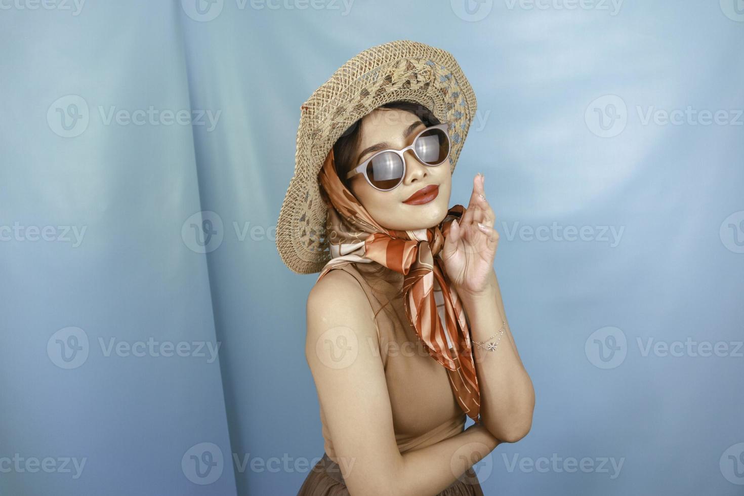 Traveling concept of a young Asian happy woman isolated by a blue background. photo