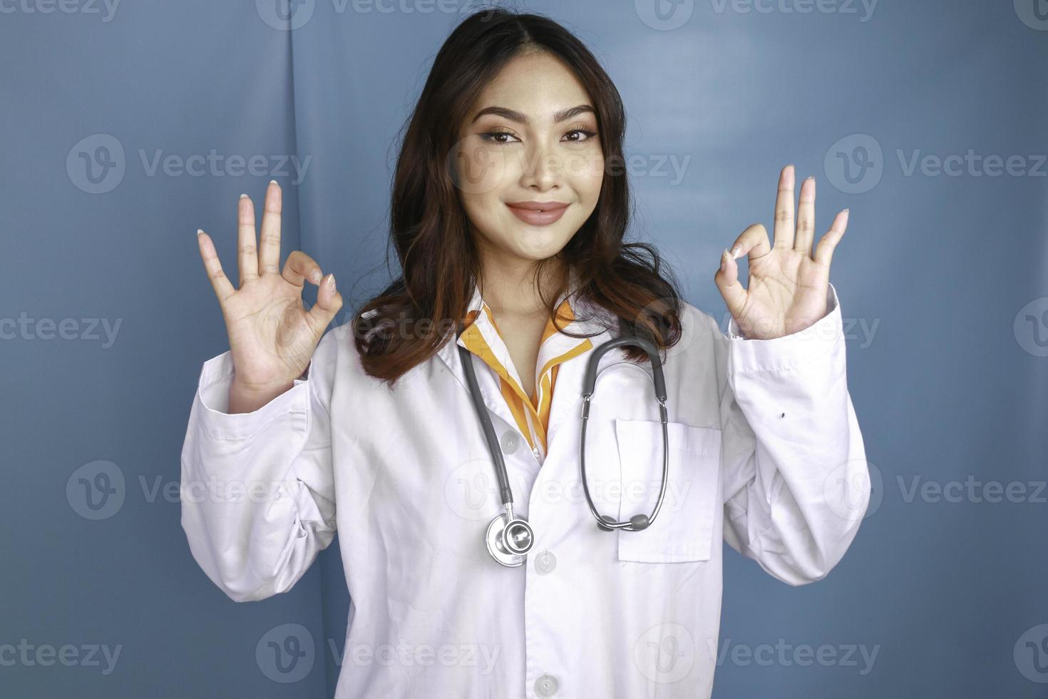 Young Asian woman doctor is smiling and showing OK sign. photo