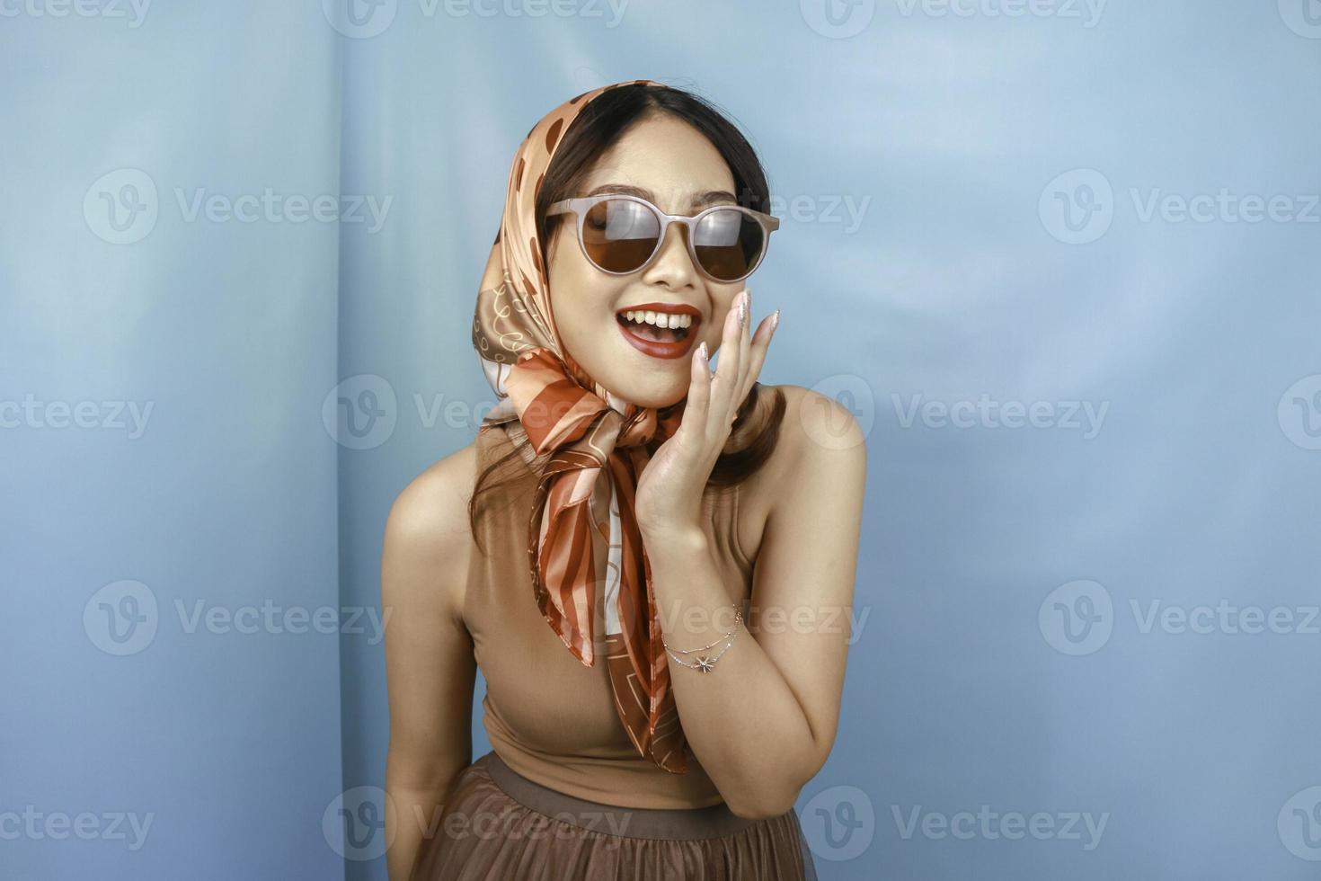 el concepto retro de una joven asiática feliz se está riendo, aislada por un fondo azul foto