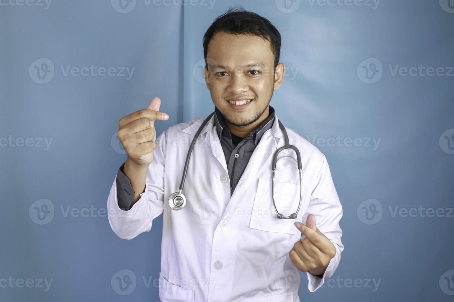 A portrait of a young Asian male doctor is showing heart finger or love gesture photo