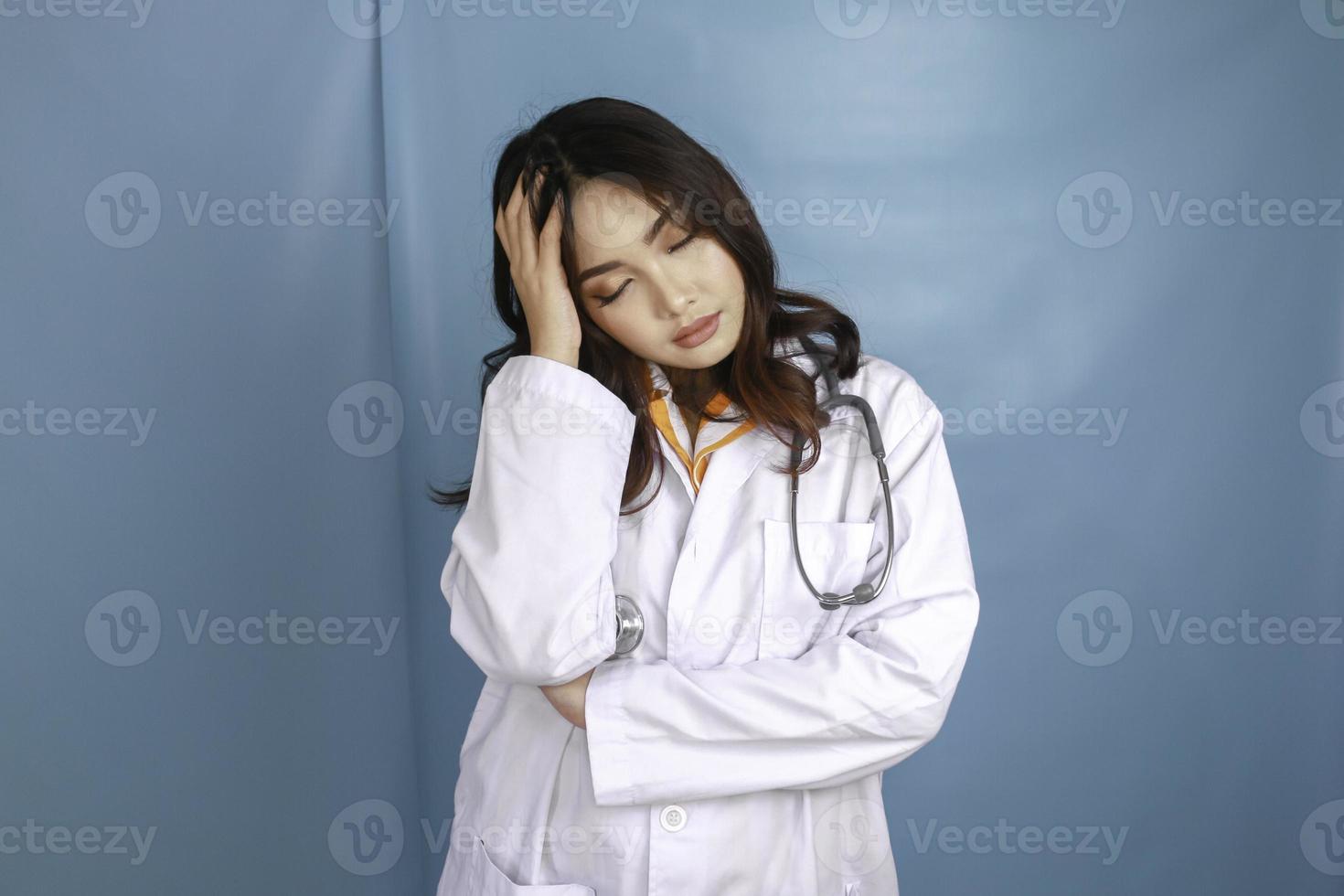 A portrait of a young Asian female doctor looks tired and overworked photo