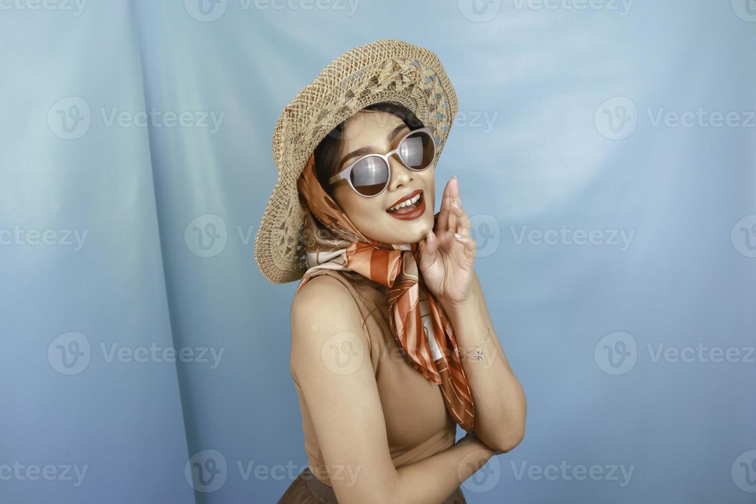 Traveling concept of a young Asian happy woman isolated by a blue background. photo