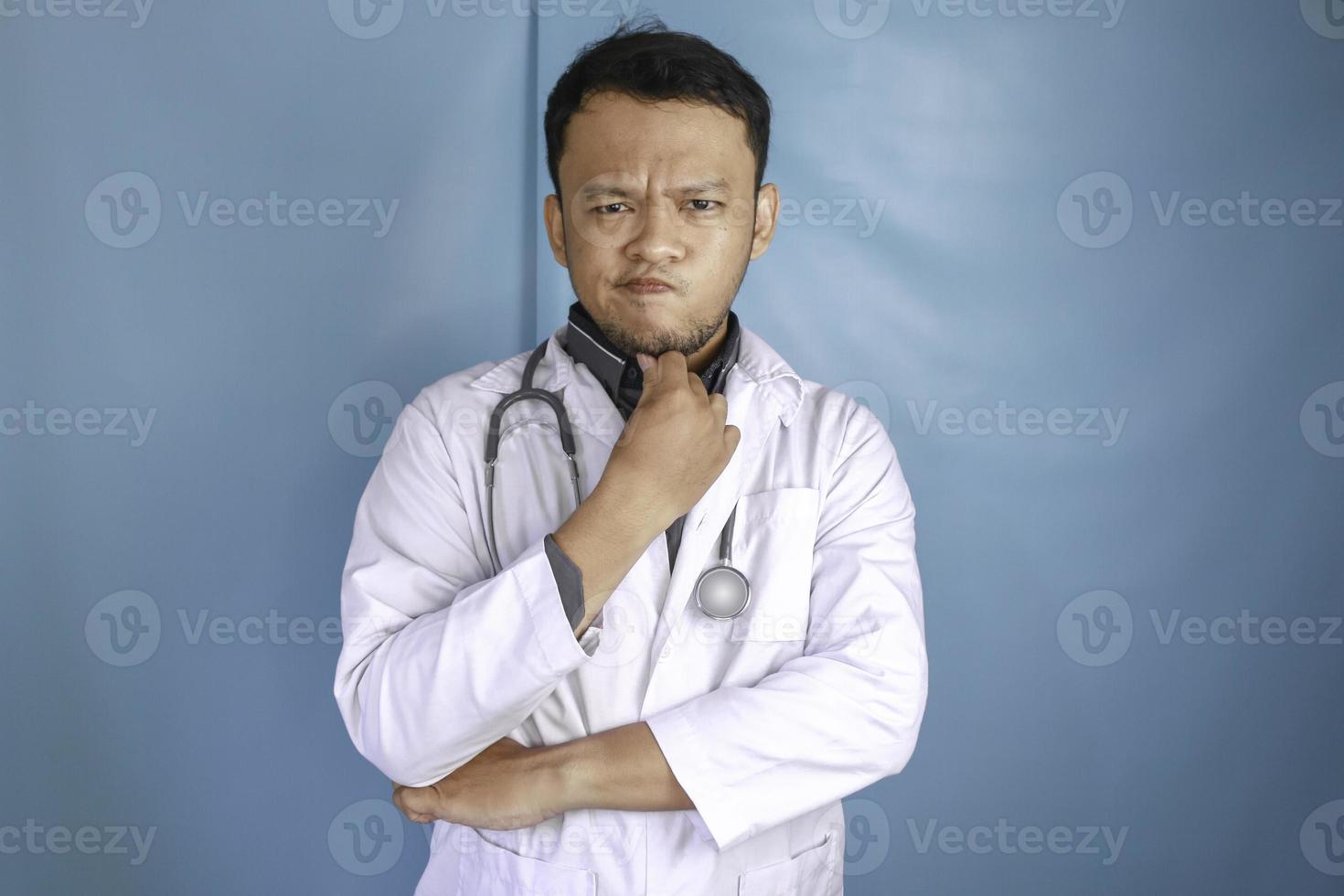 Young male doctor over isolated background thinking an idea photo