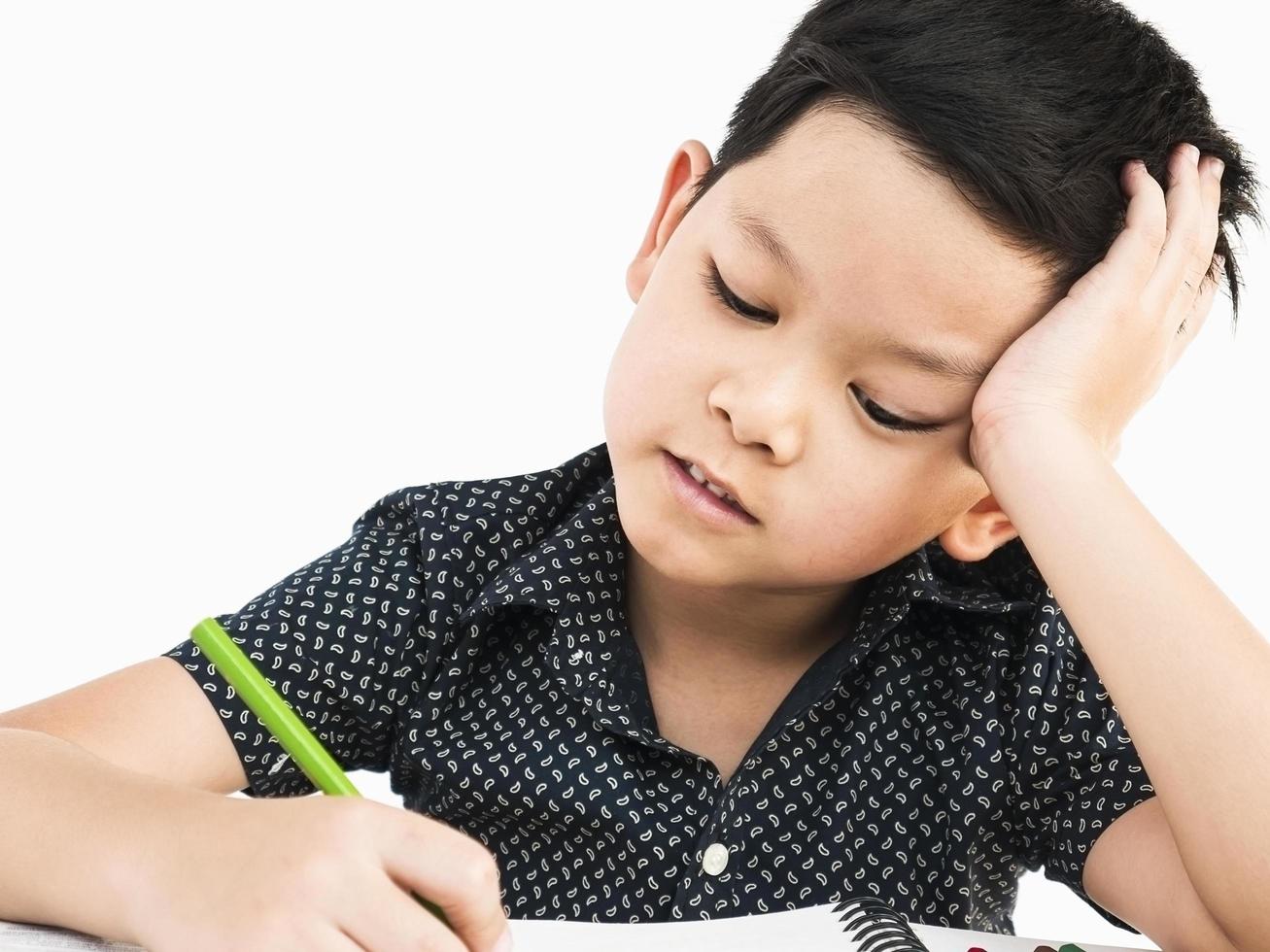 A boy is curiously doing homework photo