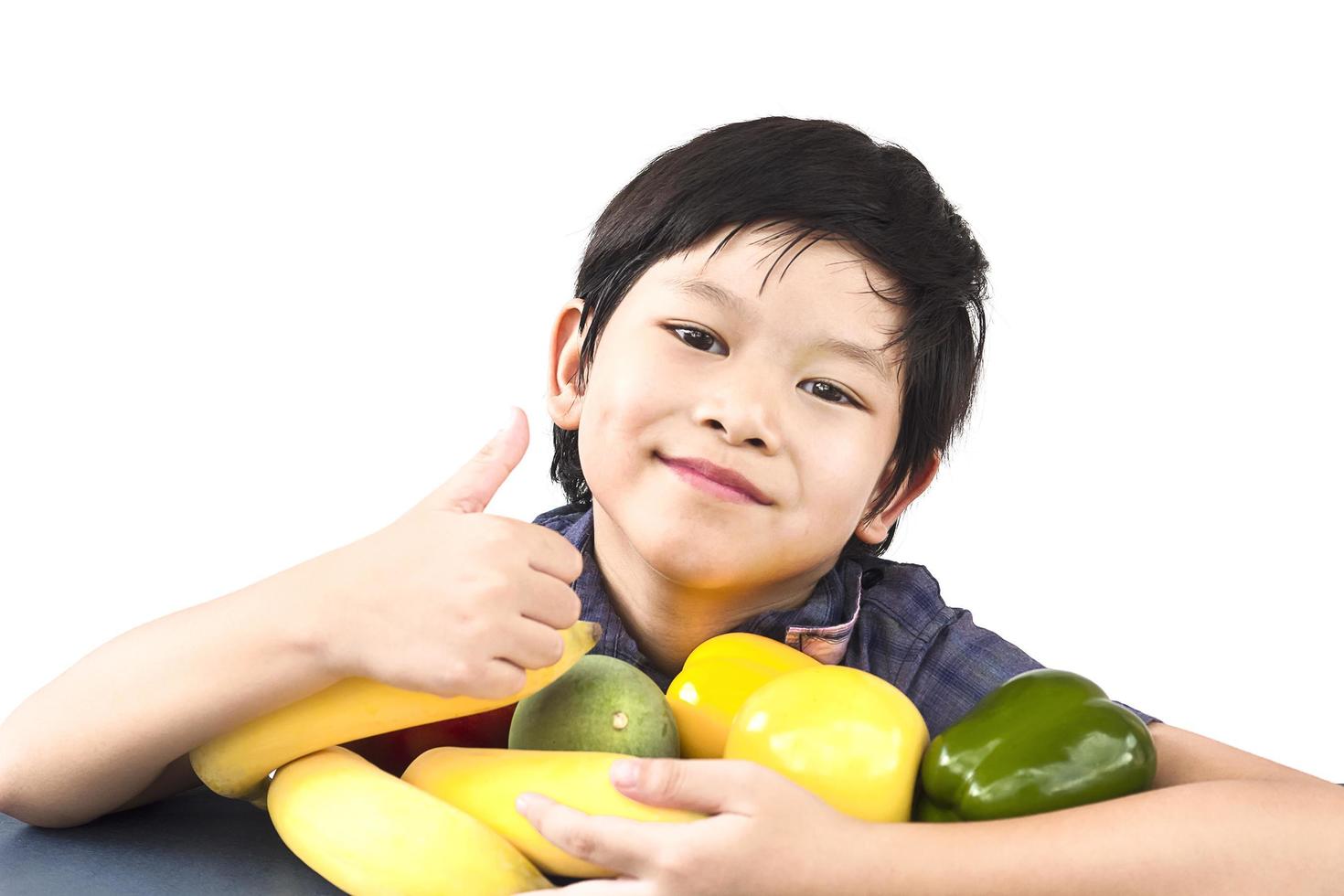 Asian healthy boy showing happy expression with variety colorful fruit and vegetable over white background photo