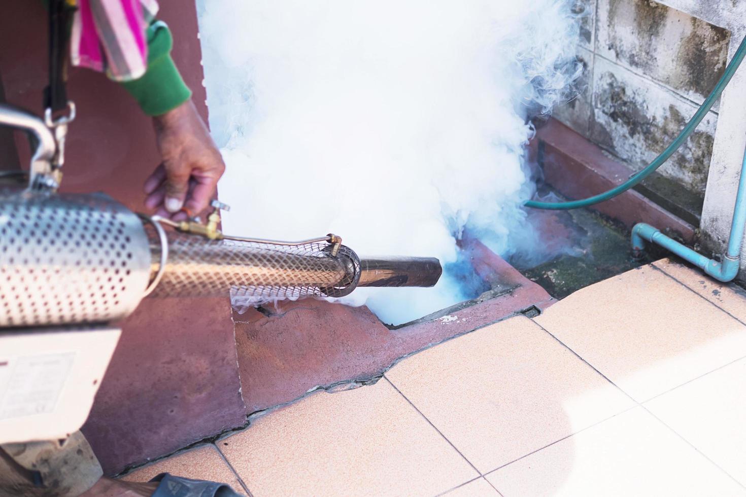 el hombre está usando una máquina de niebla térmica para proteger la propagación de mosquitos foto