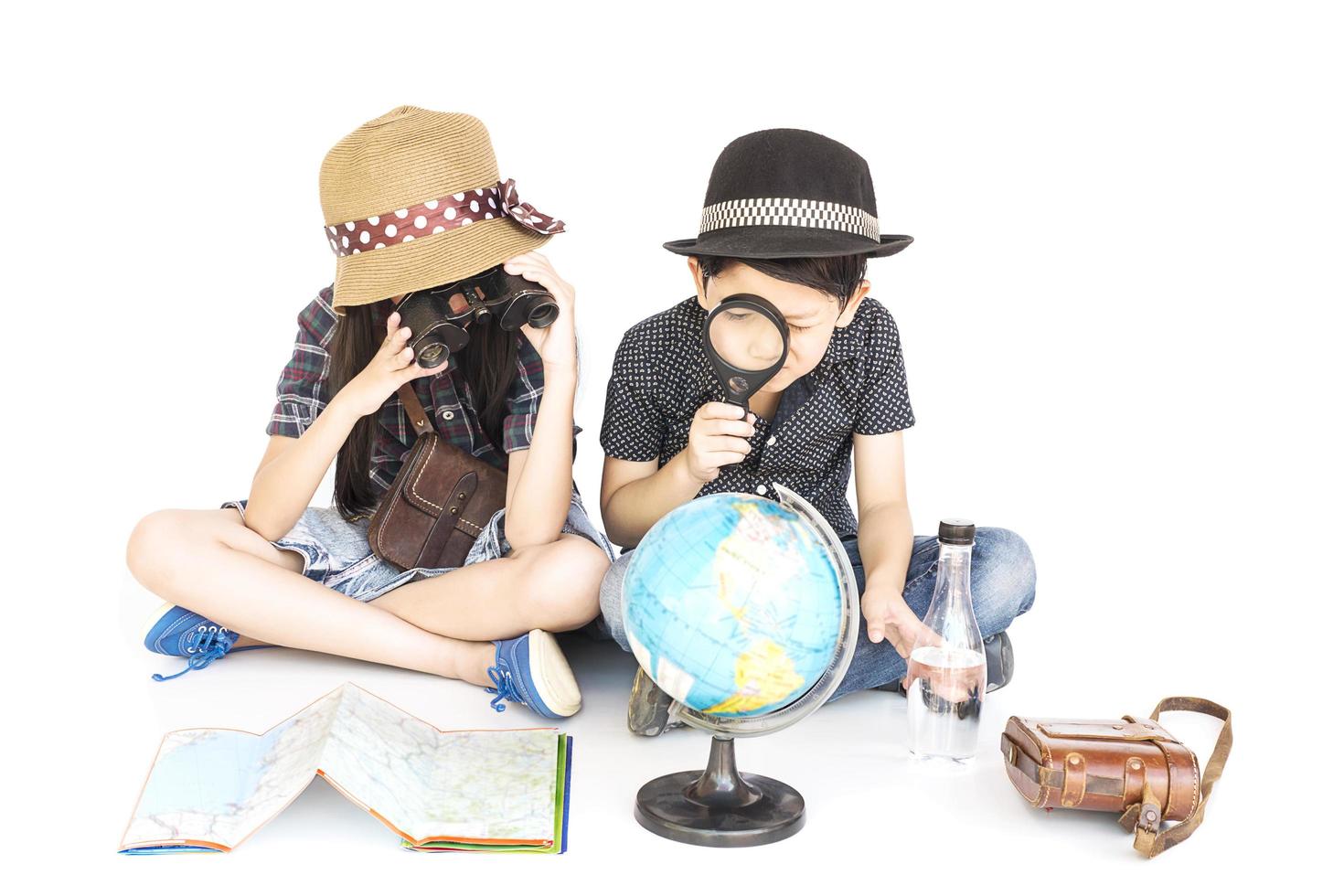 Asian boy and girl travelers are studying world map prepare to go, isolated over white background photo