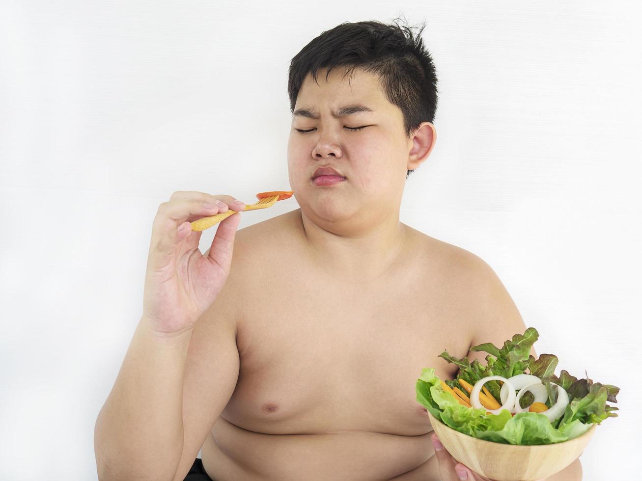 A fat boy hate to eat vegetable salad photo