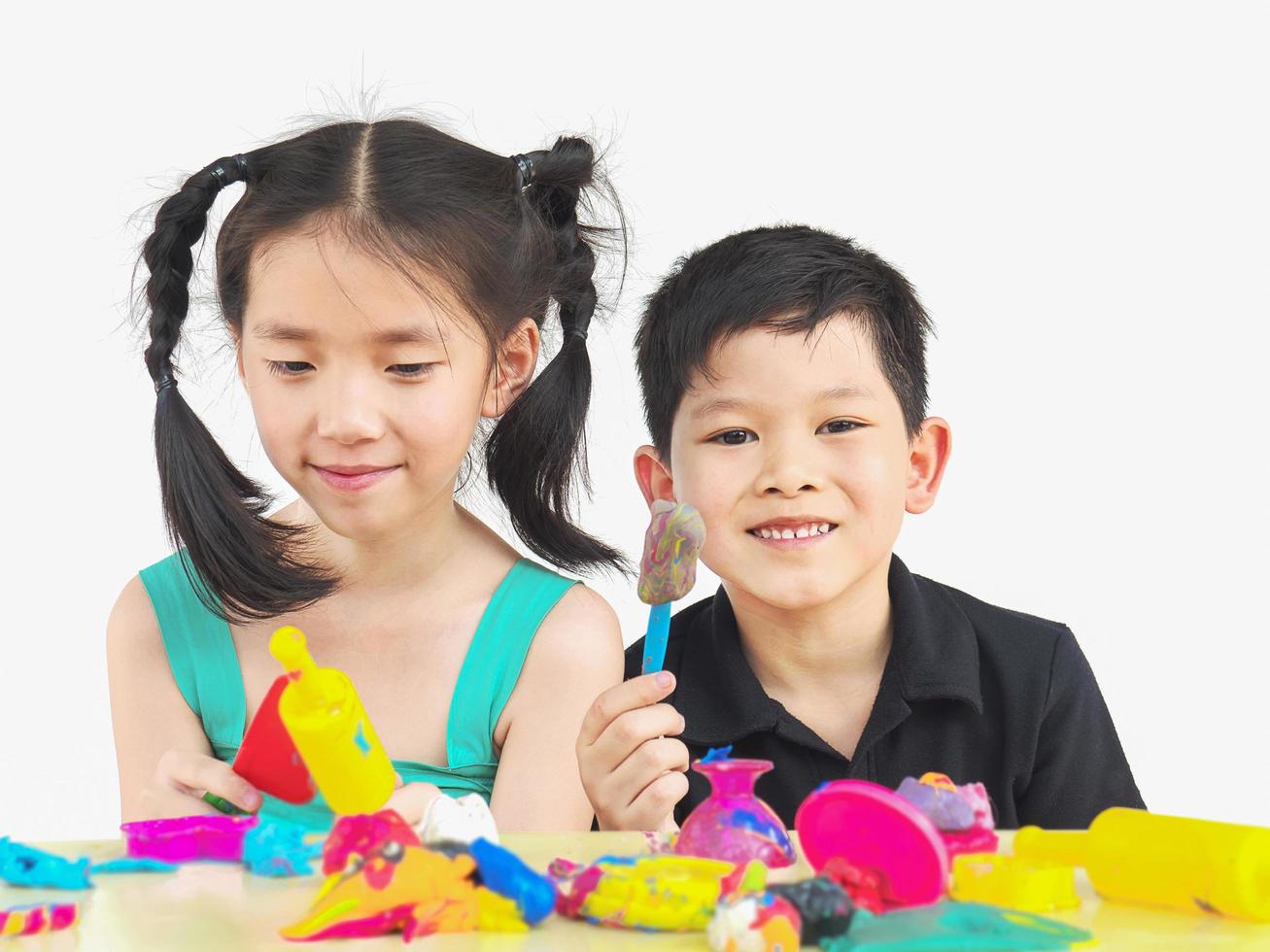 enfoque selectivo de niños asiáticos felices jugando juguetes de arcilla coloridos foto