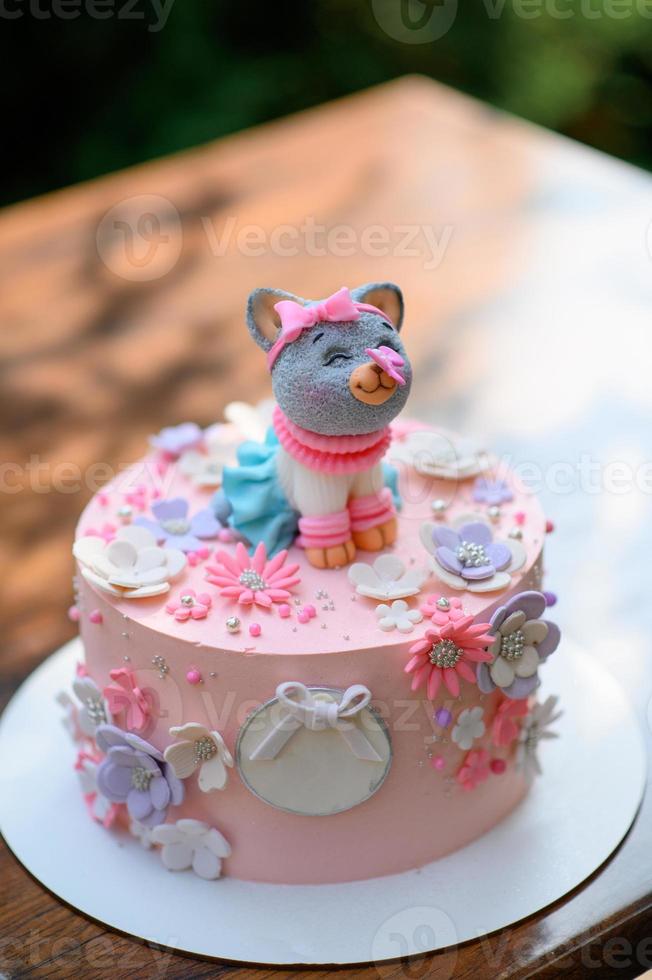 Festive pink cake with a cat on top. photo