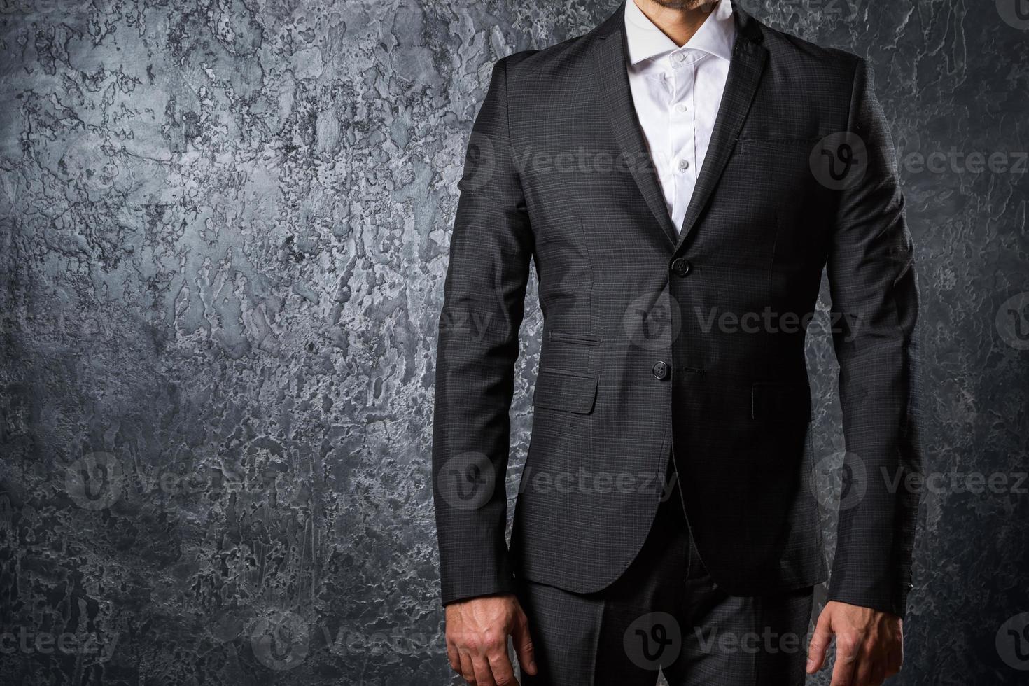 Man in suit against concrete wall photo