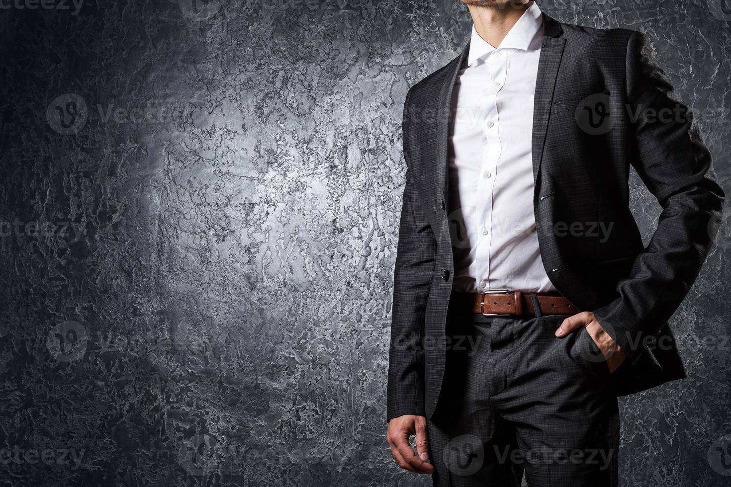 Man in suit against concrete wall photo