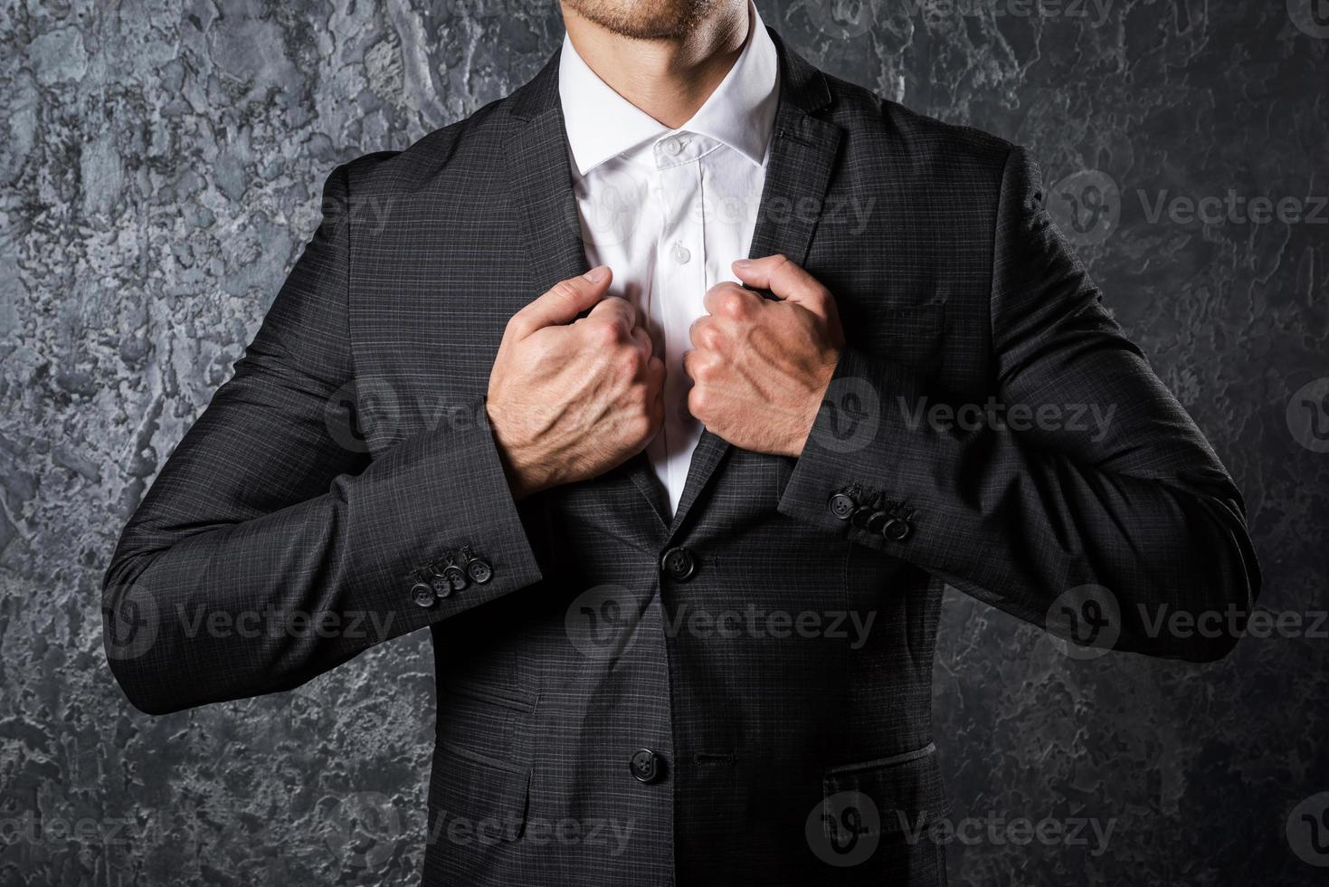 Man in suit against concrete wall photo
