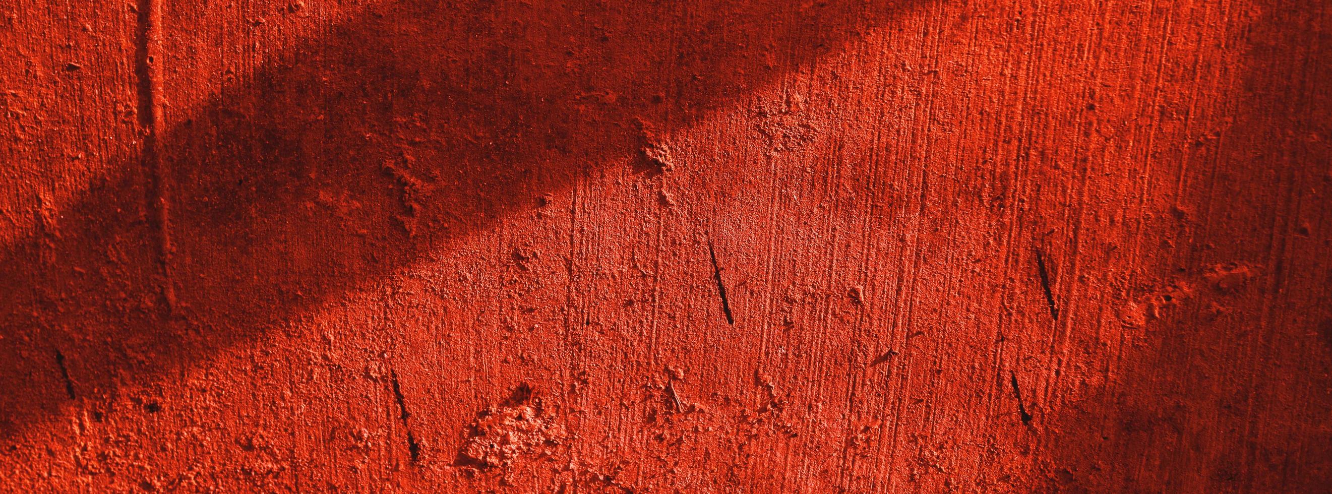 pared roja.fondo aterrador.muro de hormigón enyesado fondo de rasguño rojo.textura grunge. foto