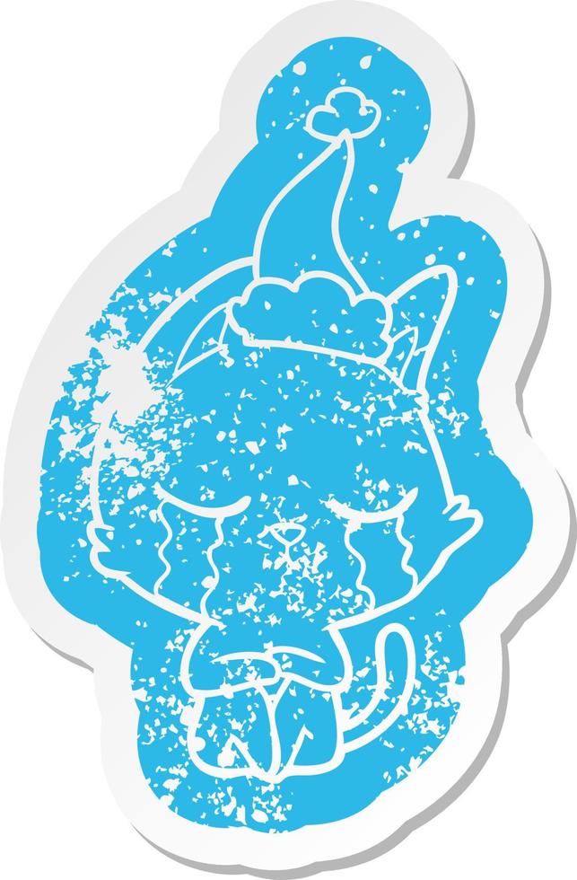 crying cartoon distressed sticker of a cat sitting wearing santa hat vector