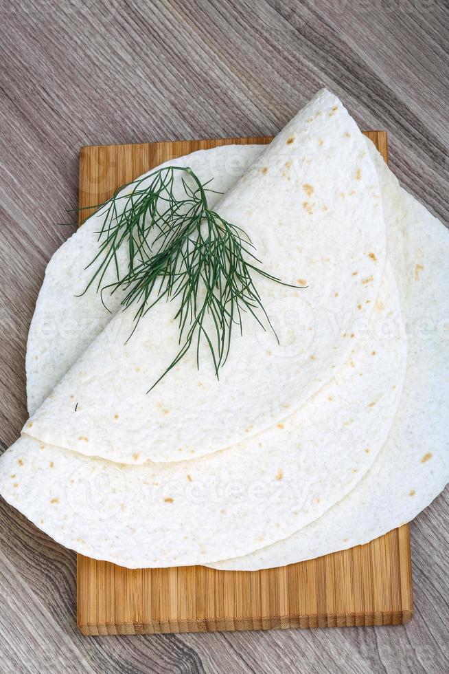 tortillas en plato de madera y fondo de madera foto