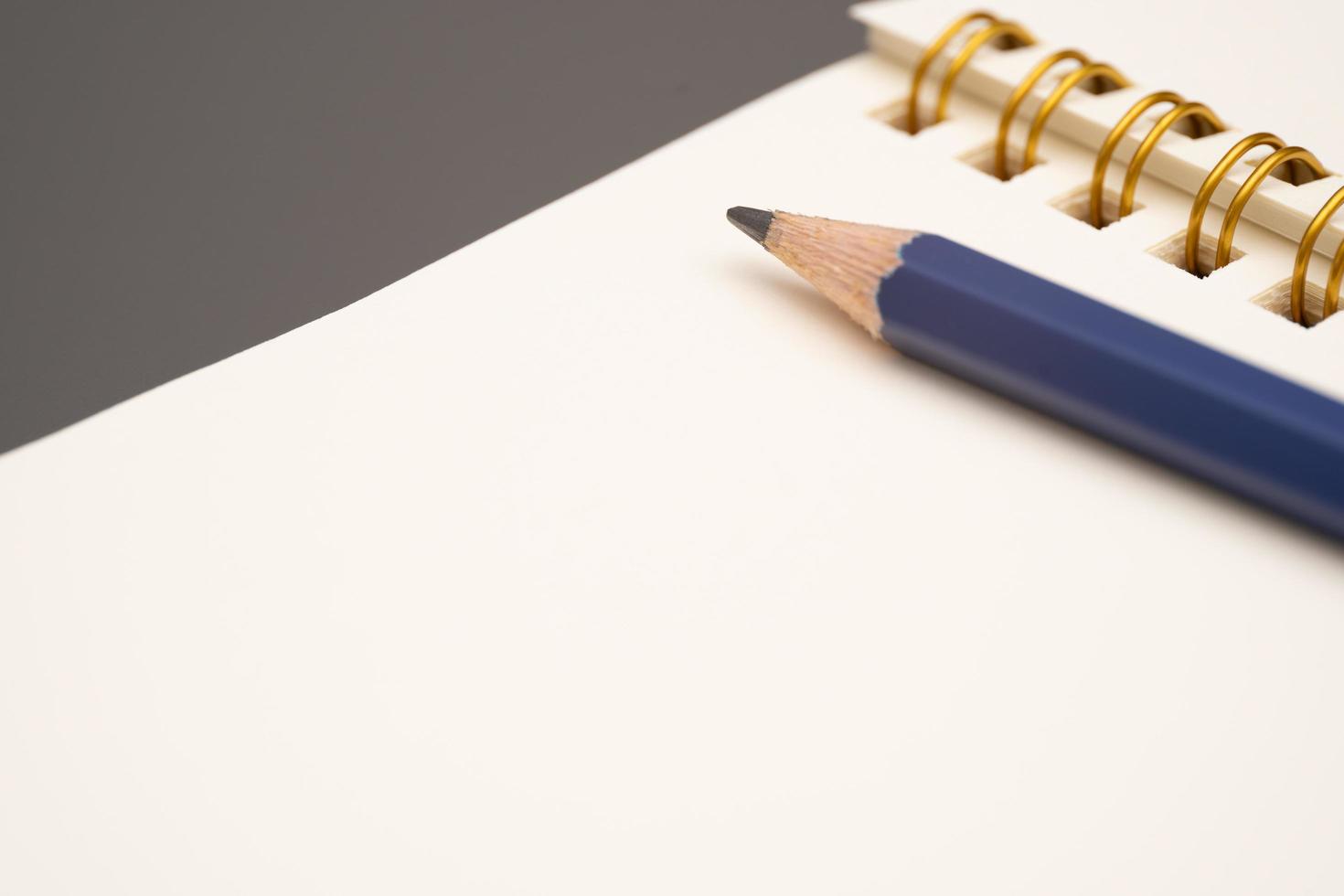 Notebook with a pencil. open spiral blank notebook with pencil on white desk background photo